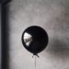 grayscale photography of balloon beside chanel metal barrel